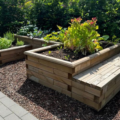 Sitzbank mit Pflanzgefäß für einen Gemeinschaftsgarten